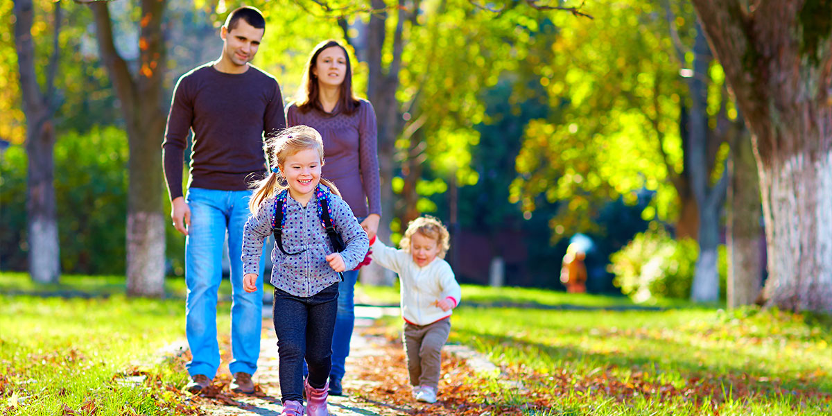 family walking down a residential sidewalk in neighborhood